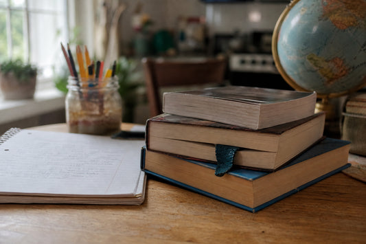 Used novels, notebook, pencils, and globe on a kitchen table for short books for eighth grade book reports.