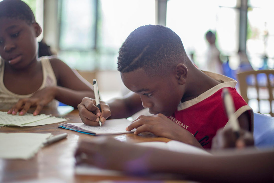Children doing schoolwork at a table – Complete Homeschool Reading List