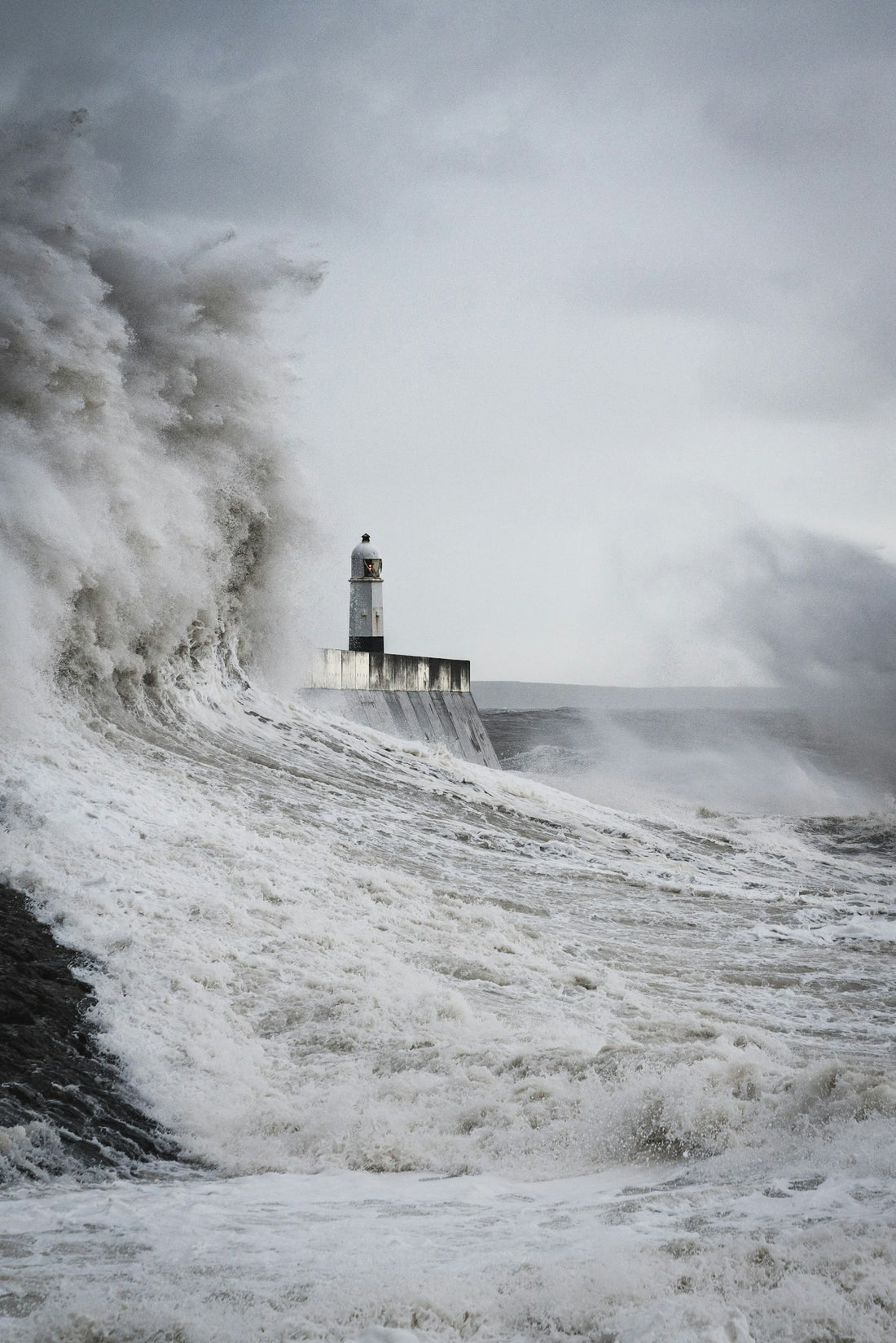 A lighthouse struck by a huge wave – H.P. Lovecraft Books in Order