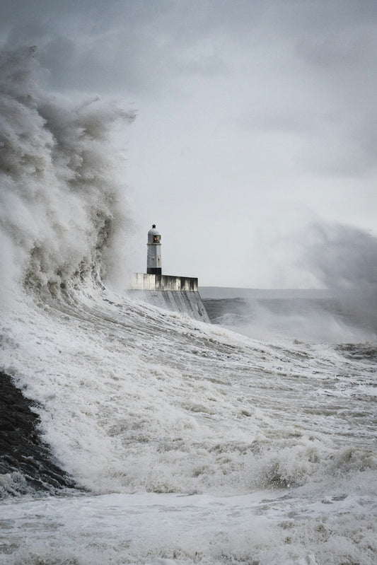 A lighthouse struck by a huge wave – H.P. Lovecraft Books in Order