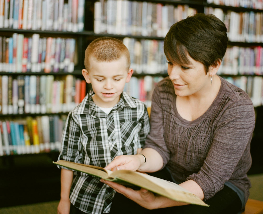 A woman and a child reading together in a library – Best Read-Aloud Chapter Books for Families